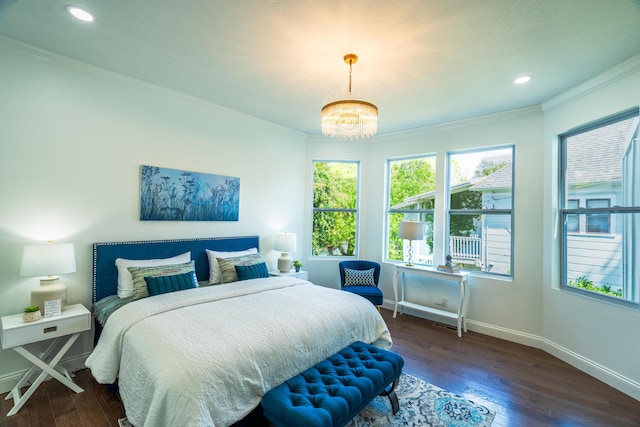 bedroom featuring a notable chandelier, ornamental molding, and dark wood-type flooring