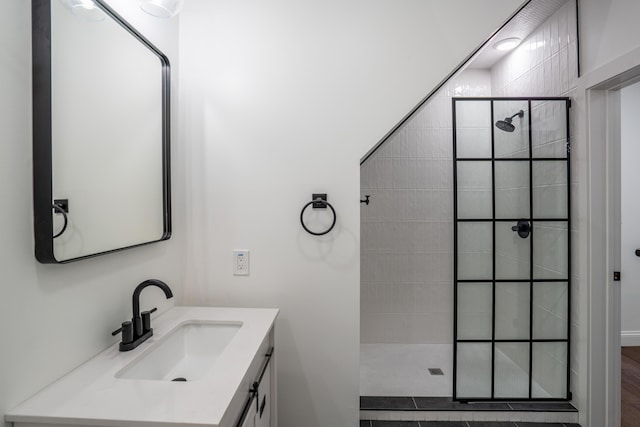 bathroom with vanity and a tile shower