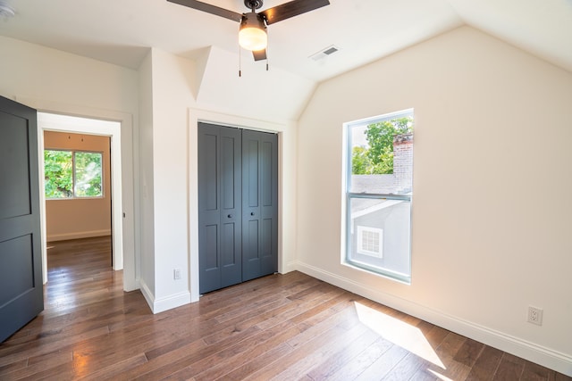 unfurnished bedroom with a closet, vaulted ceiling, ceiling fan, and dark wood-type flooring