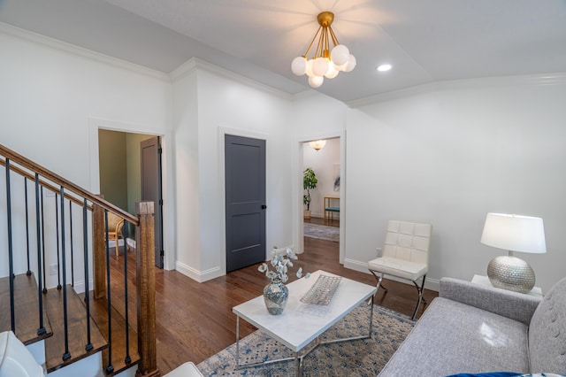 living room featuring dark hardwood / wood-style floors, vaulted ceiling, crown molding, and an inviting chandelier