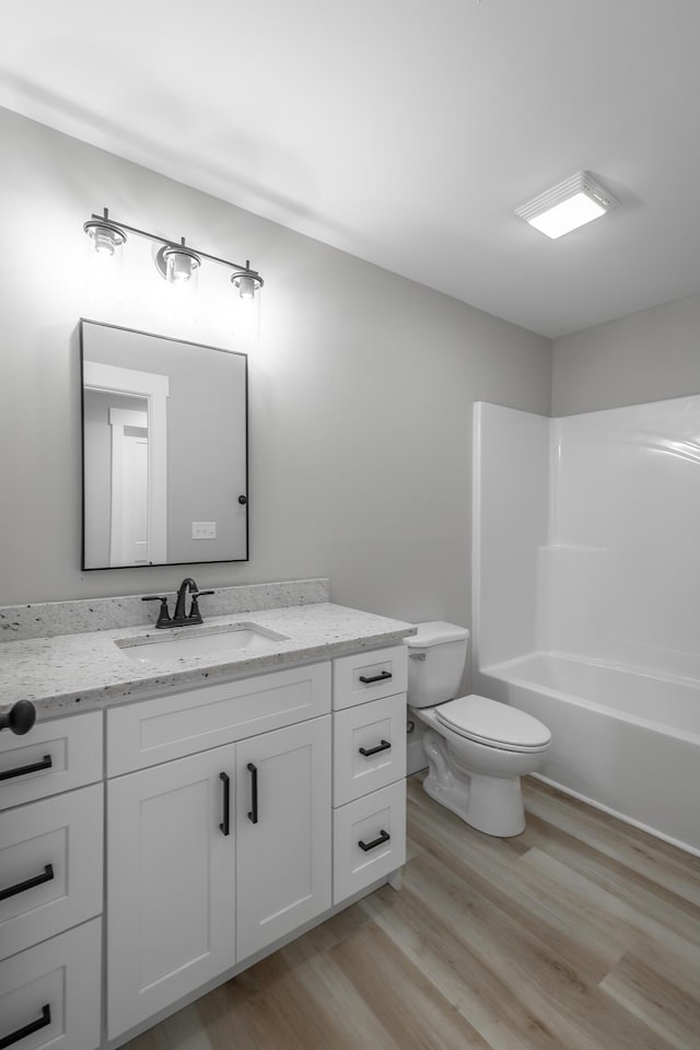 full bathroom featuring vanity, toilet, wood-type flooring, and tub / shower combination