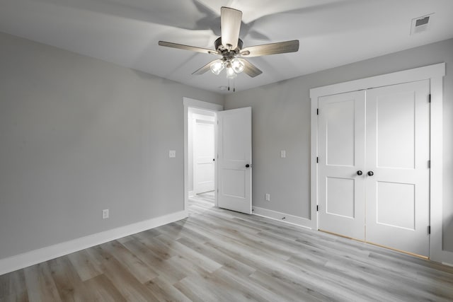 unfurnished bedroom with ceiling fan, light hardwood / wood-style floors, and a closet