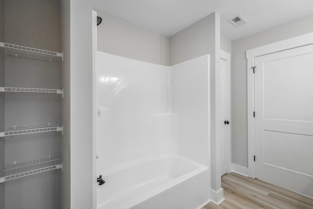 bathroom featuring independent shower and bath and wood-type flooring