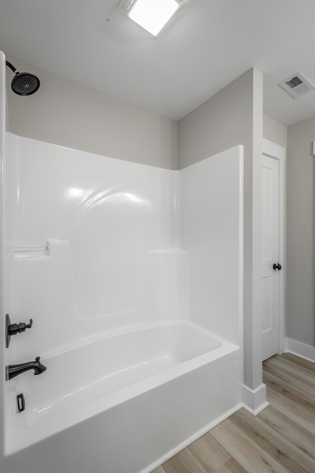 bathroom featuring hardwood / wood-style flooring and shower / washtub combination