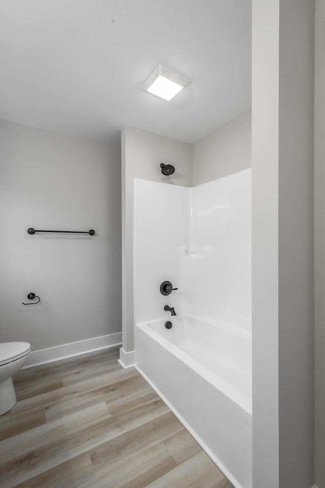 bathroom featuring hardwood / wood-style floors, toilet, and shower / bathing tub combination