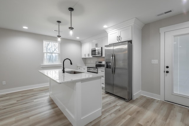 kitchen featuring sink, light stone countertops, decorative light fixtures, white cabinetry, and stainless steel appliances