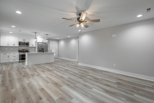 unfurnished living room featuring ceiling fan and light wood-type flooring