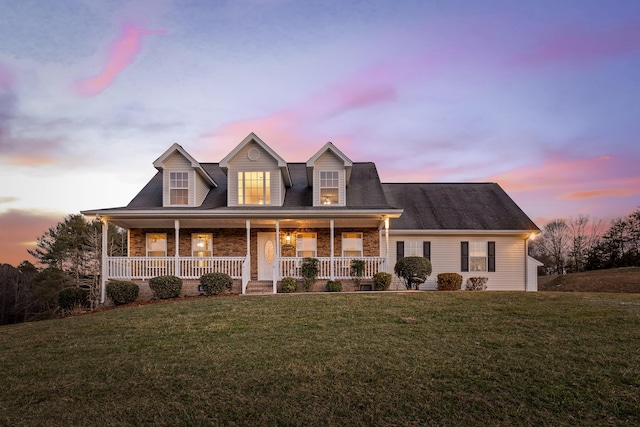 cape cod house featuring a lawn and a porch