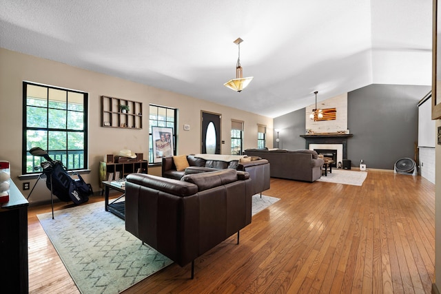 living room with a fireplace, light hardwood / wood-style floors, and lofted ceiling