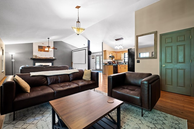 living room with wood-type flooring, ceiling fan, and lofted ceiling