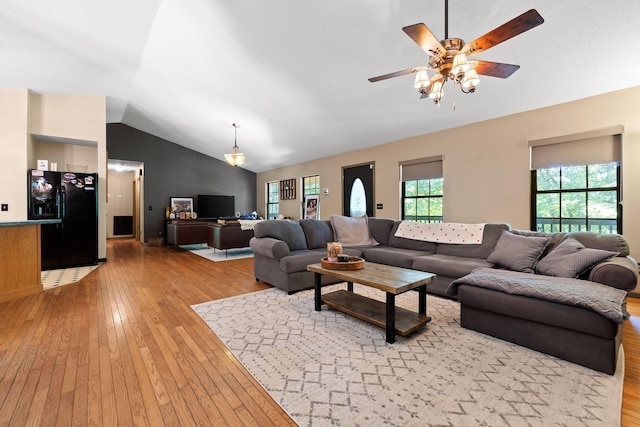 living room featuring ceiling fan, light hardwood / wood-style floors, and vaulted ceiling