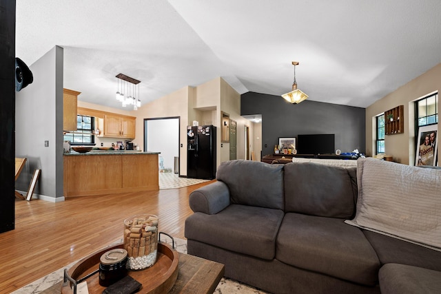 living room featuring light hardwood / wood-style floors and vaulted ceiling