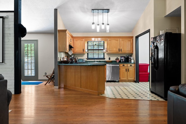 kitchen featuring dishwasher, black fridge with ice dispenser, light hardwood / wood-style floors, and sink