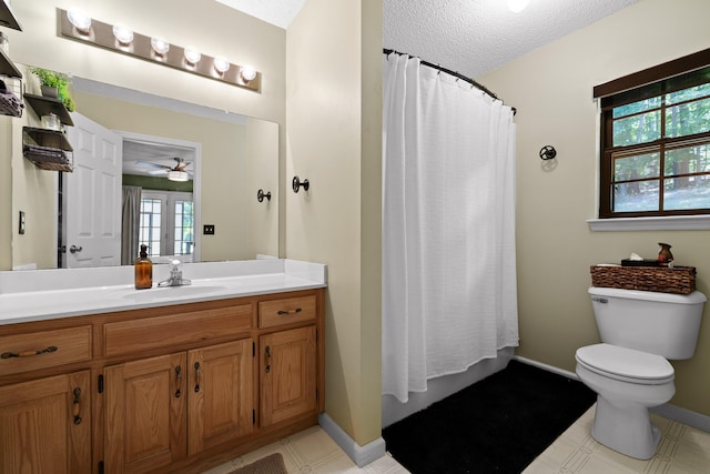 bathroom with ceiling fan, vanity, a textured ceiling, and toilet