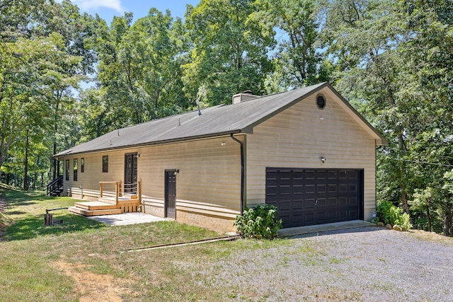 view of home's exterior with a yard, a deck, and a garage