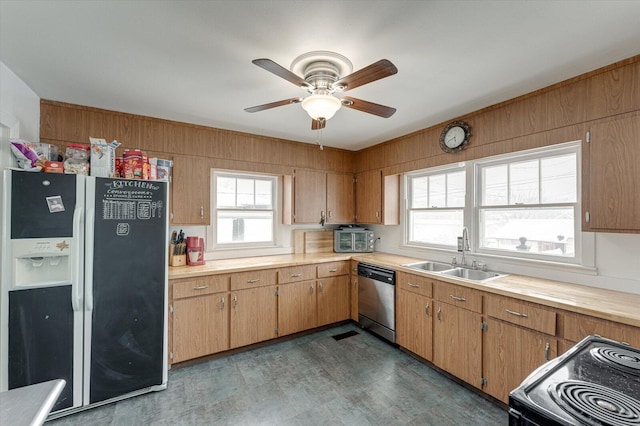 kitchen with ceiling fan, sink, stainless steel dishwasher, range with electric stovetop, and black fridge with ice dispenser