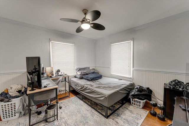 bedroom with ceiling fan, crown molding, and hardwood / wood-style flooring