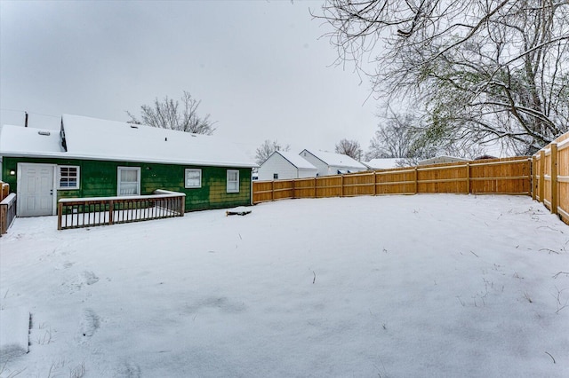 yard covered in snow featuring a deck