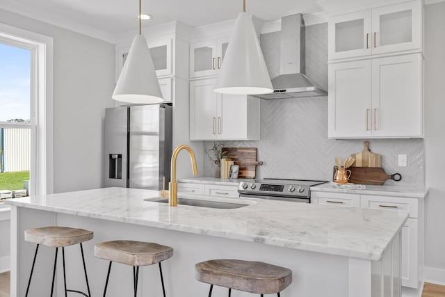 kitchen with backsplash, stainless steel appliances, sink, wall chimney range hood, and white cabinets