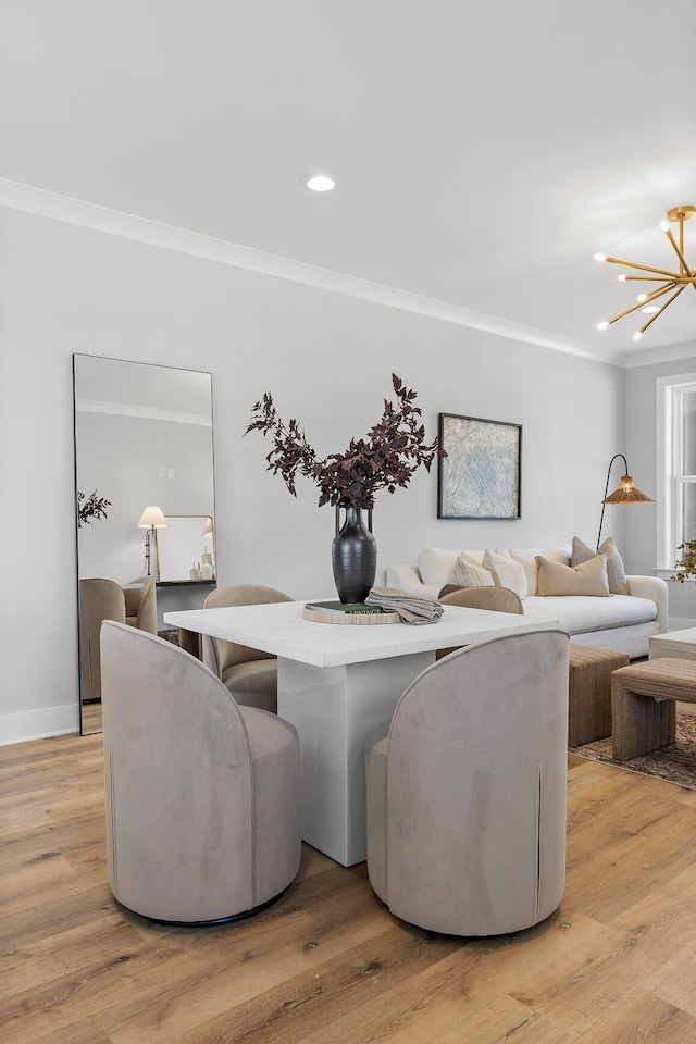 dining area with an inviting chandelier, light hardwood / wood-style flooring, and crown molding