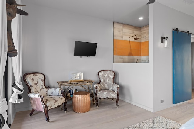 living area featuring light wood-type flooring and a barn door