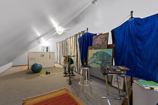 exercise room with vaulted ceiling and carpet floors