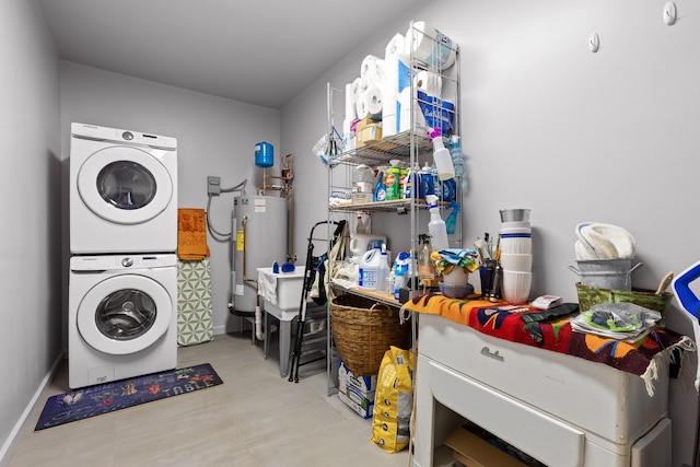 clothes washing area with gas water heater and stacked washer / drying machine