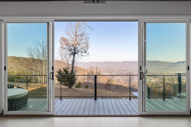 doorway with a mountain view and light wood-type flooring