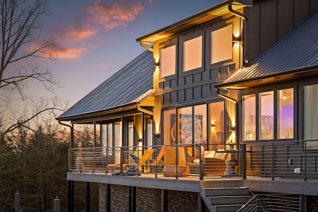 back house at dusk featuring a balcony