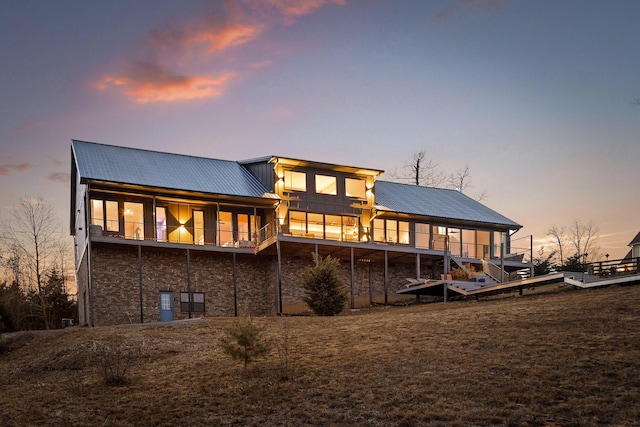 back house at dusk with a lawn