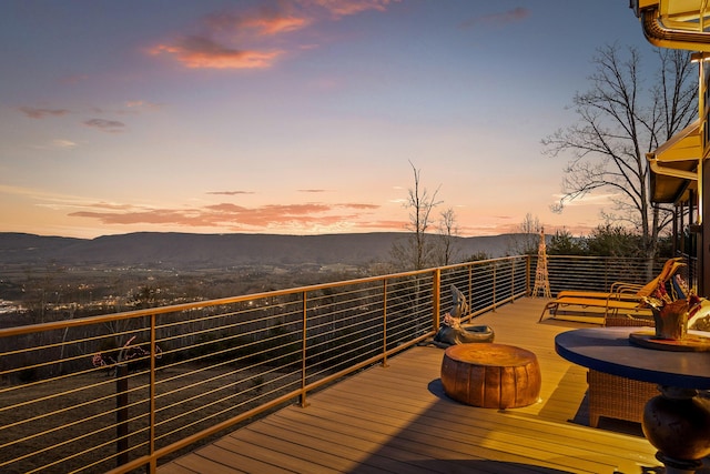 deck at dusk featuring a mountain view