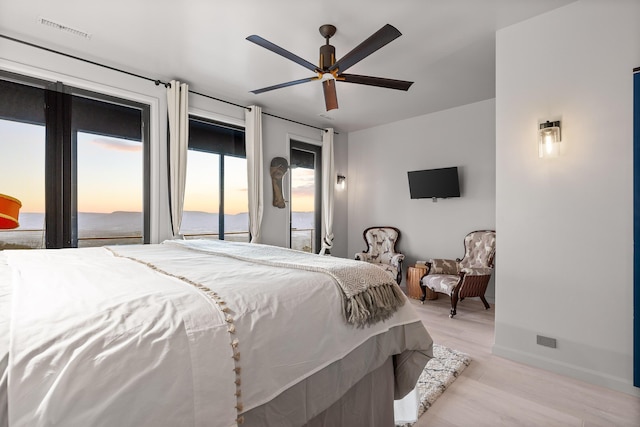 bedroom with light wood-type flooring, ceiling fan, and access to outside