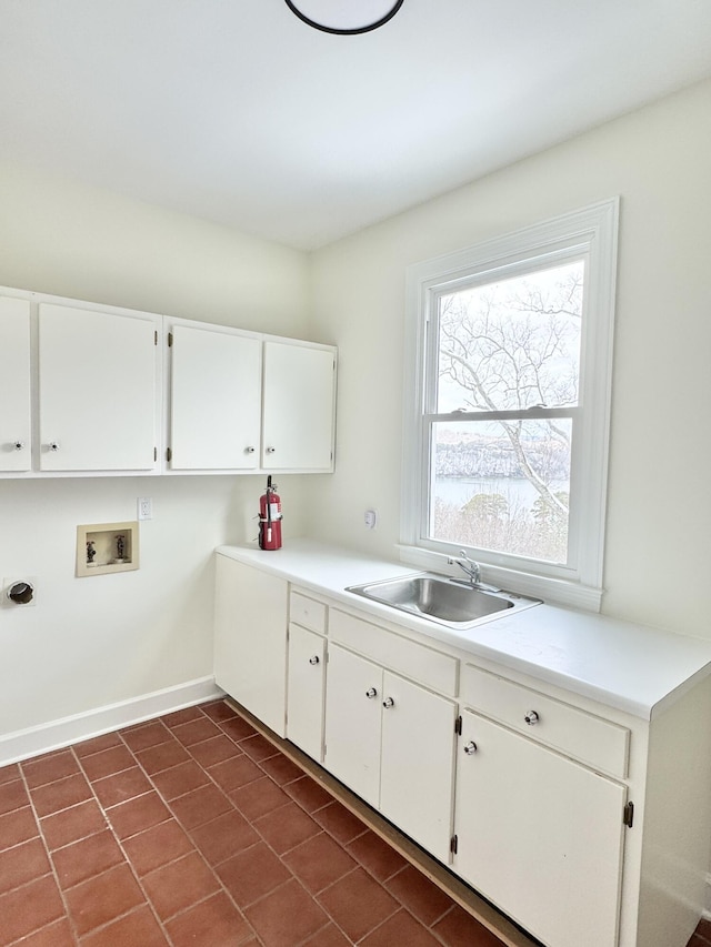 clothes washing area featuring cabinets, washer hookup, dark tile patterned floors, and sink