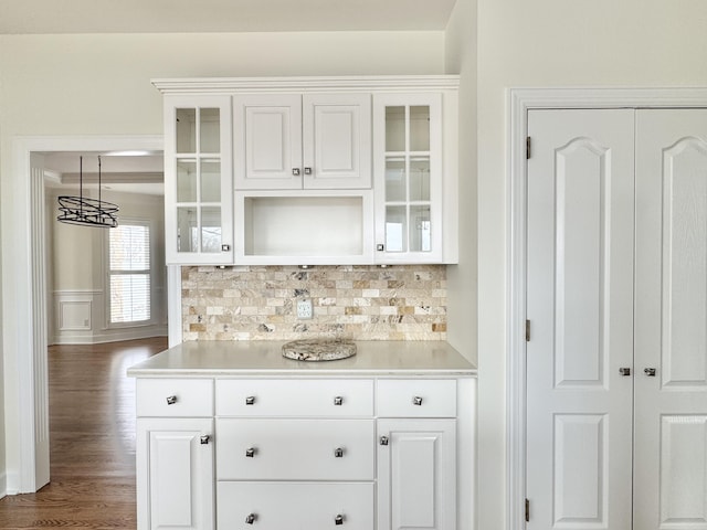 bar with pendant lighting, decorative backsplash, white cabinetry, and dark wood-type flooring