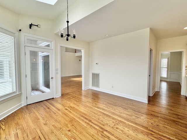 interior space featuring light hardwood / wood-style flooring and a notable chandelier