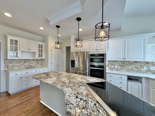 kitchen with white cabinets, hanging light fixtures, backsplash, and appliances with stainless steel finishes