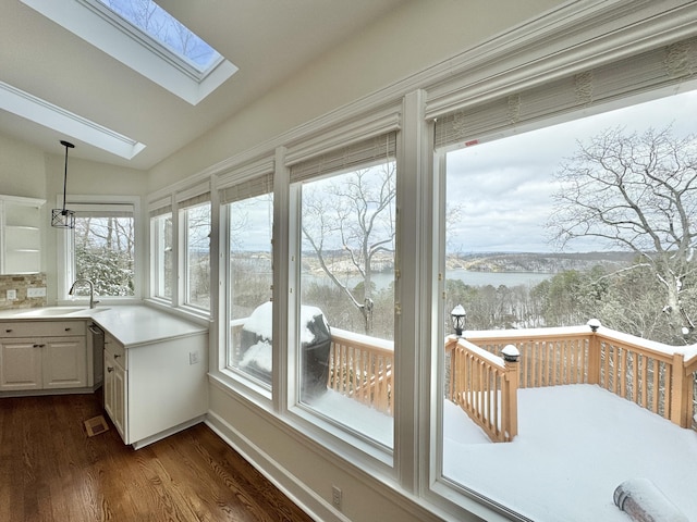 unfurnished sunroom featuring lofted ceiling with skylight and sink