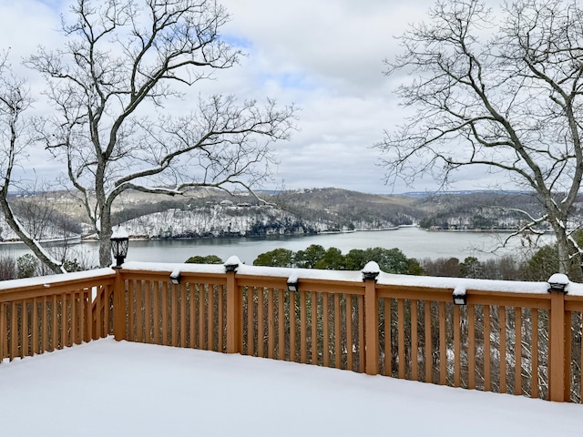 snow covered deck featuring a water view