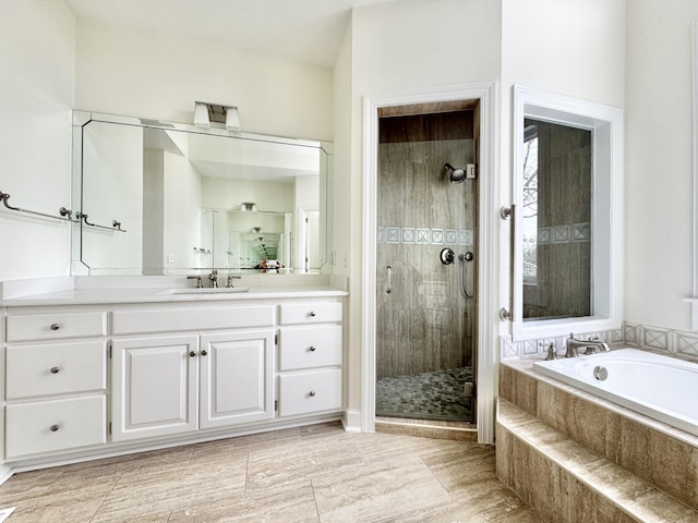 bathroom with vanity and shower with separate bathtub