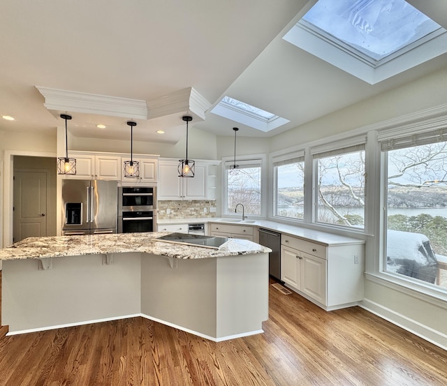 kitchen with white cabinetry, a center island, and appliances with stainless steel finishes