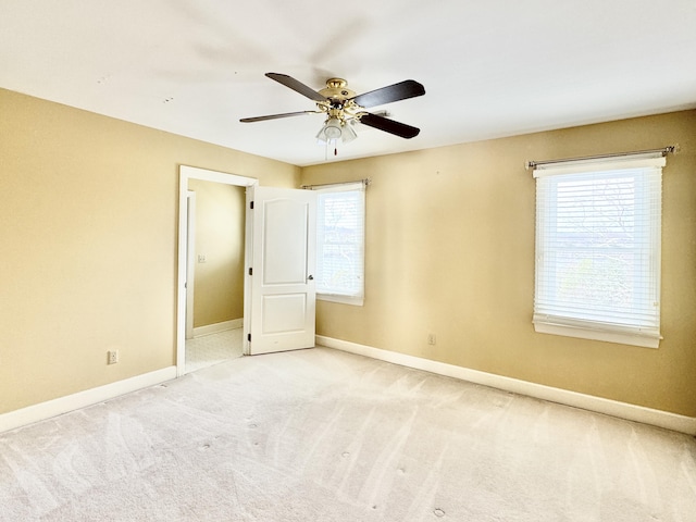 carpeted spare room with a wealth of natural light and ceiling fan