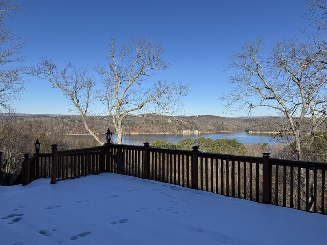 snow covered deck with a water view