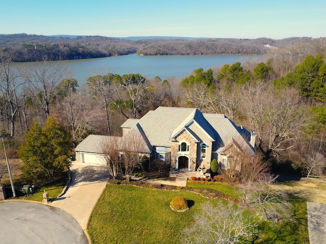 exterior space with a water view, a garage, and a front lawn