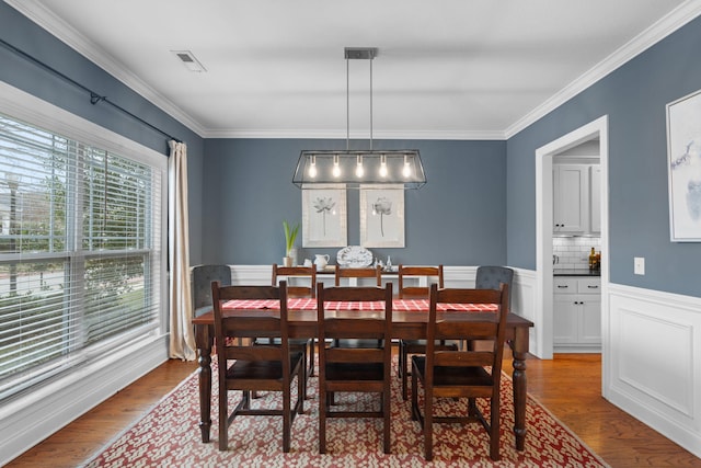 dining room featuring wood-type flooring and crown molding