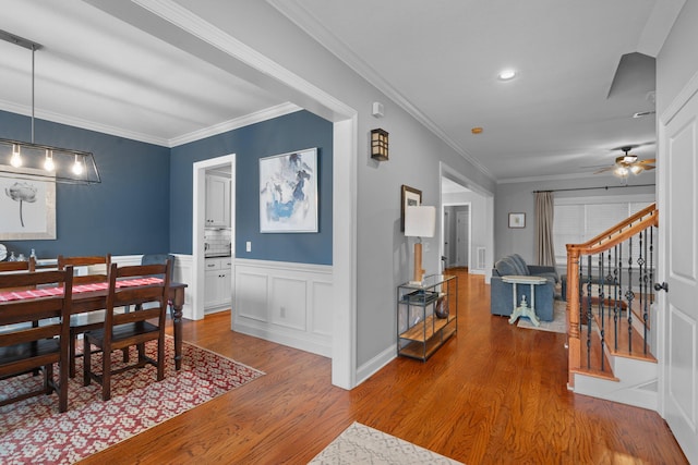 dining space featuring ceiling fan, ornamental molding, and hardwood / wood-style floors