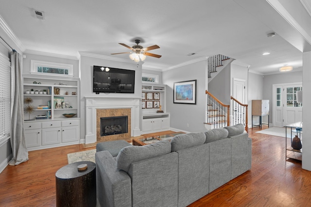 living room with a fireplace, crown molding, and hardwood / wood-style flooring