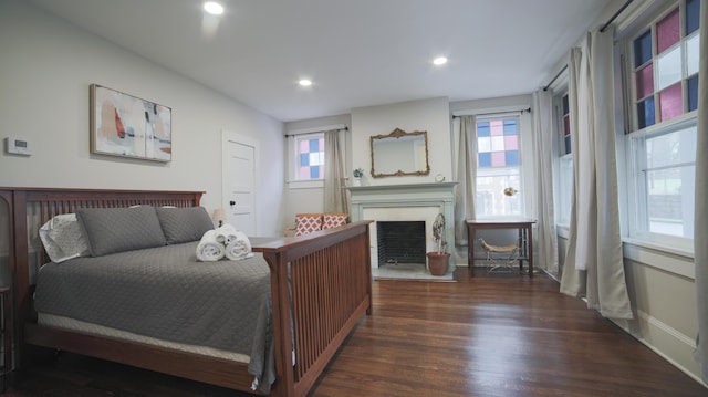 bedroom with multiple windows and dark hardwood / wood-style flooring