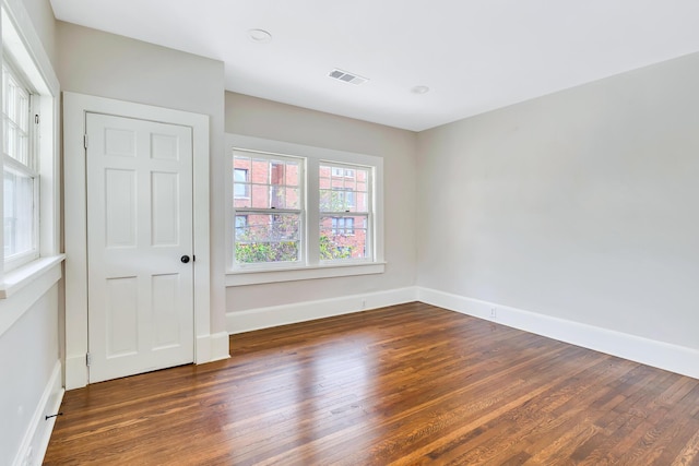 unfurnished room with dark hardwood / wood-style flooring