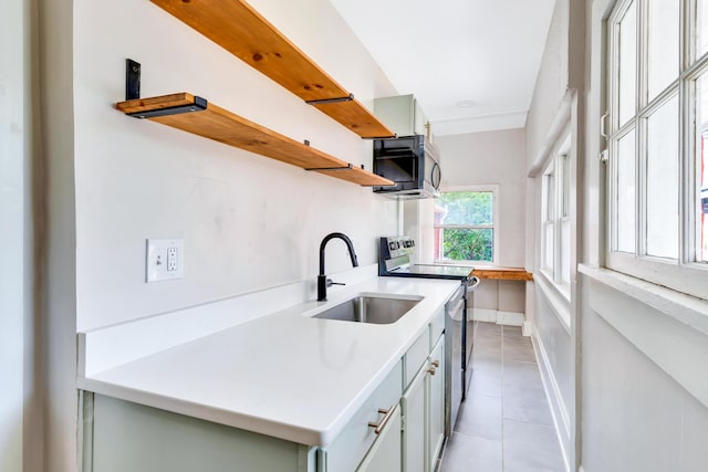 kitchen featuring appliances with stainless steel finishes, sink, and light tile patterned floors