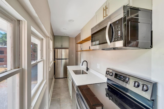 kitchen with sink, light tile patterned flooring, and appliances with stainless steel finishes